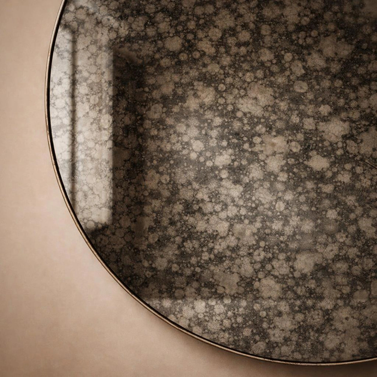Close-up of charcoal antiqued mirror surface showing dark mottled foxing