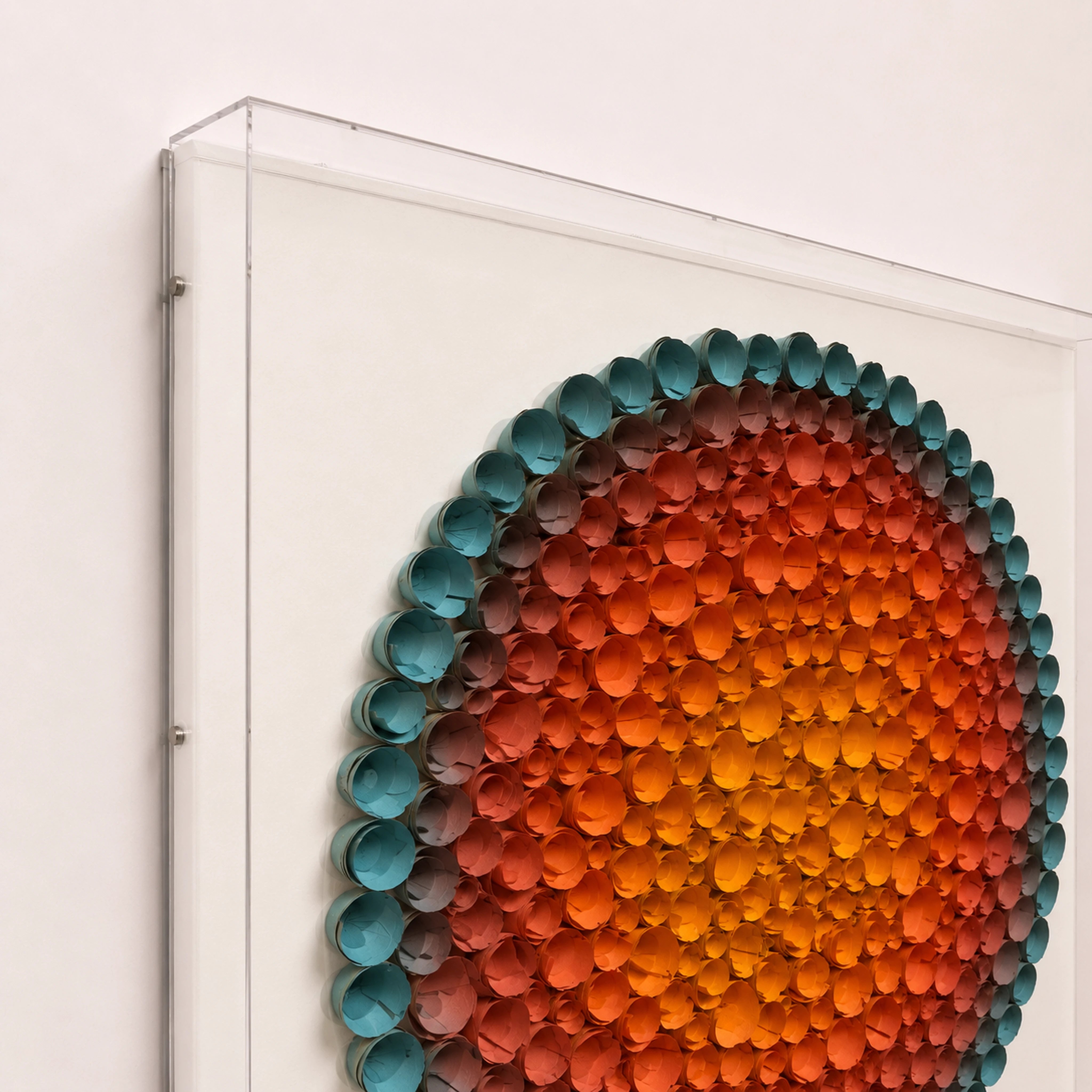 Coronal Bloom — orange and blue round paper wall art in a clear acrylic shadow box — angled view of the acrylic shadow box