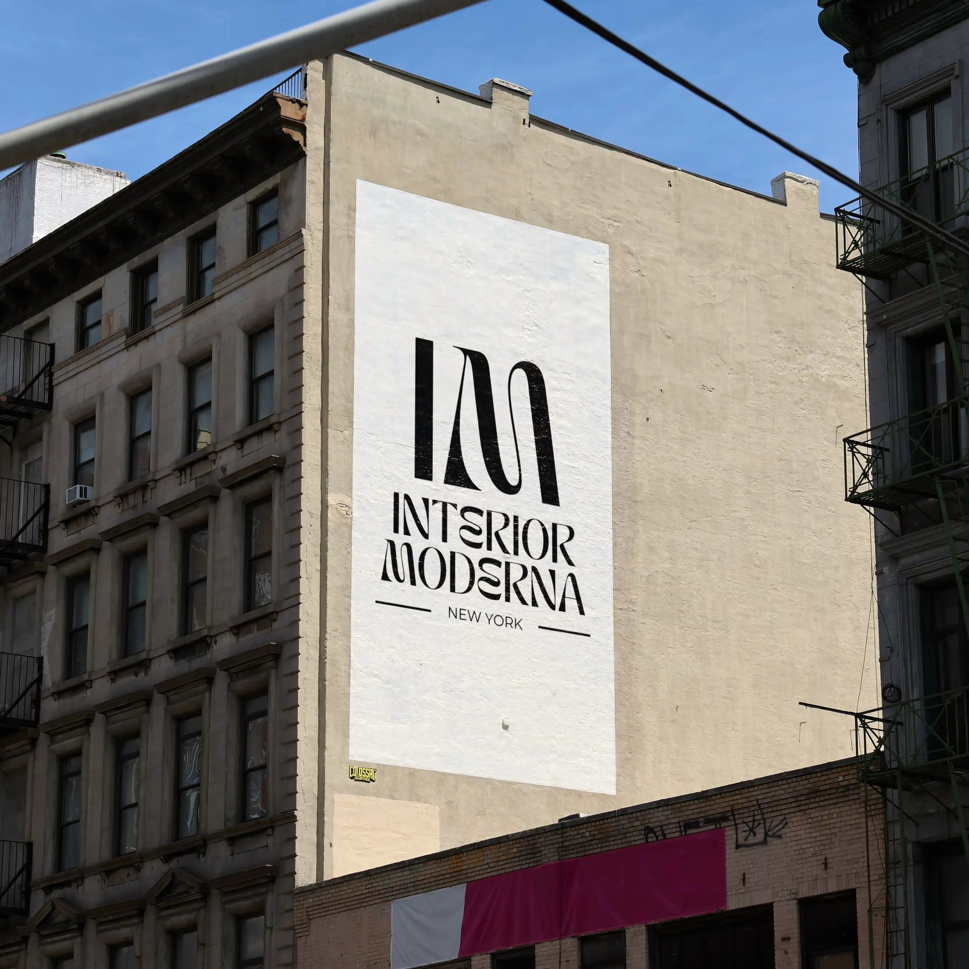 Large "Interior Moderna" logo mural in bold black letters on a white building facade in New York City, representing modern design.