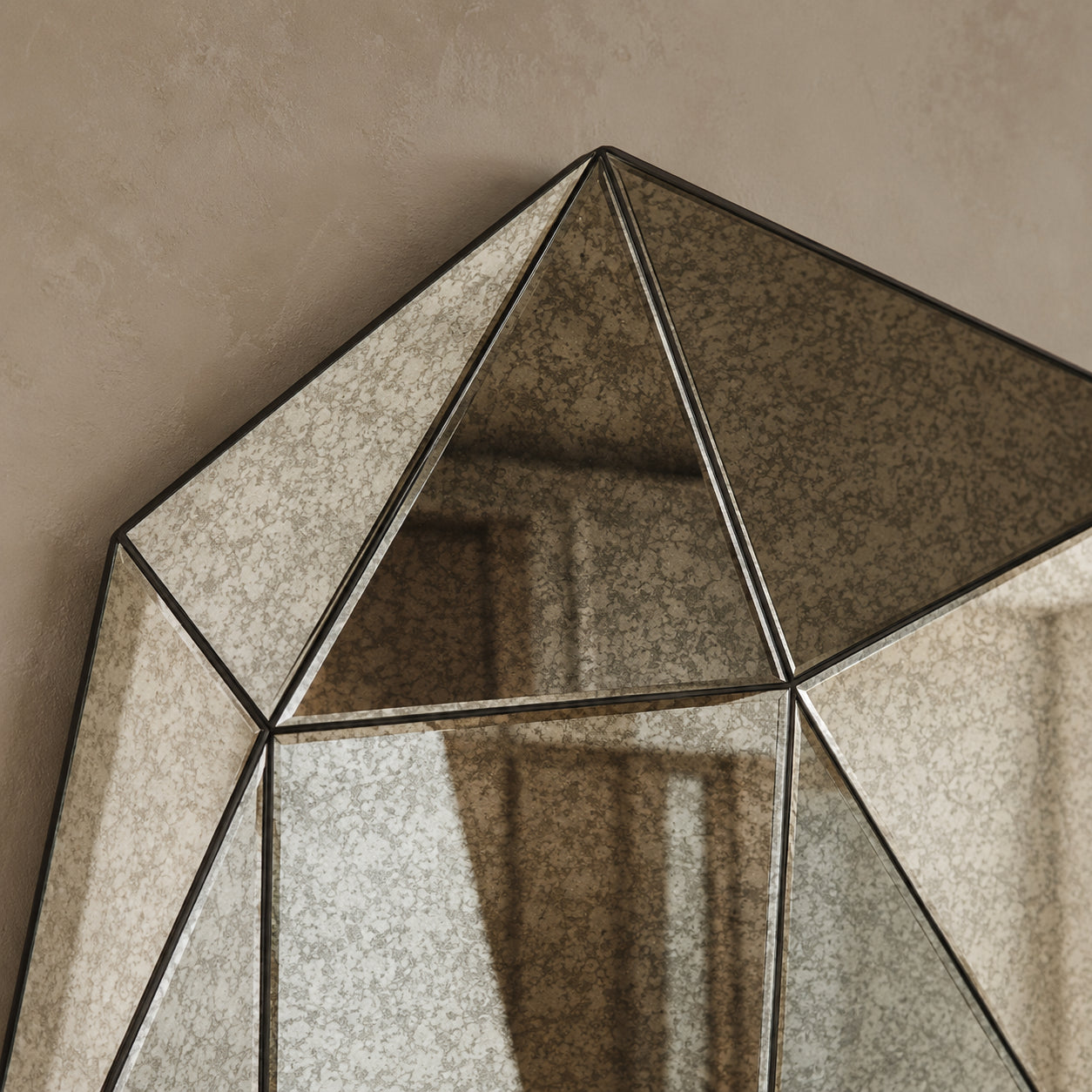 Antiqued smoke mirror upper facet detail — canted triangular panels with speckled mercury patina