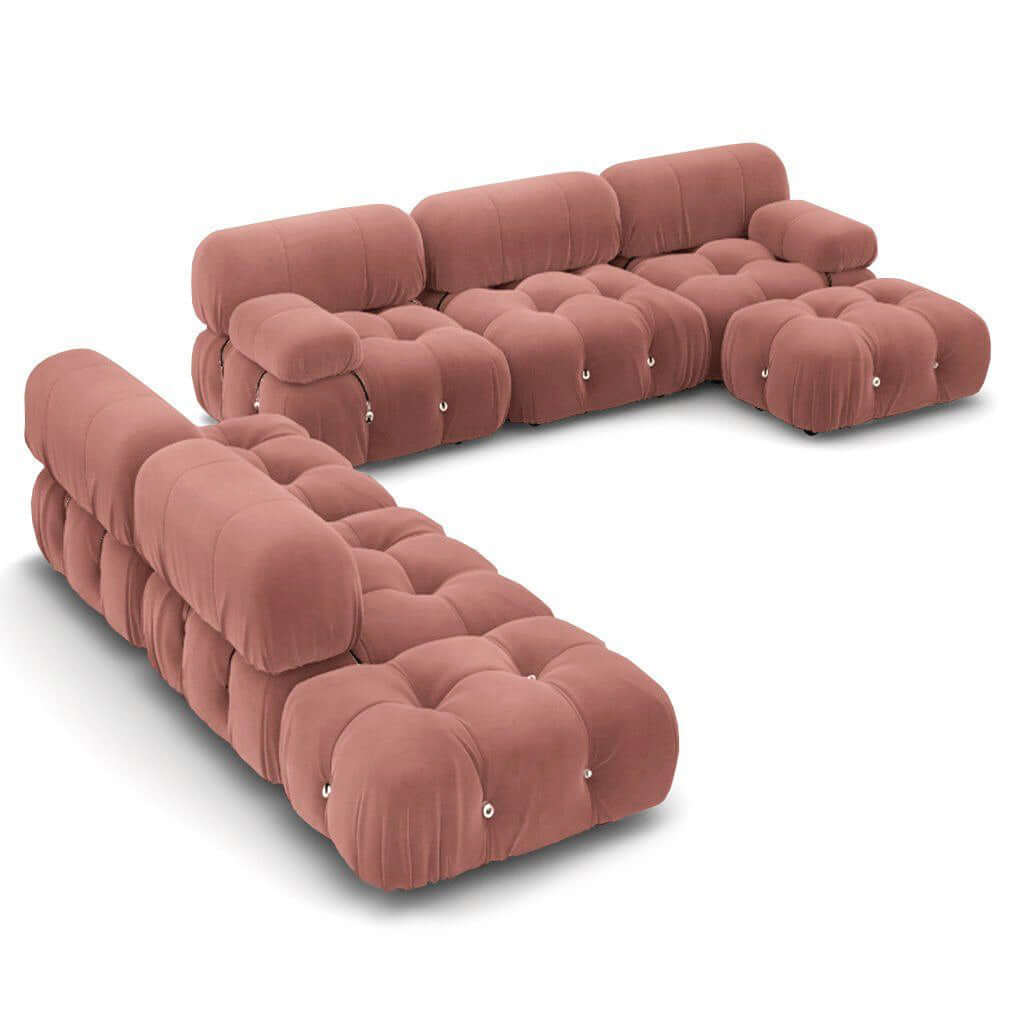 Plush modular sofa set in dusty rose with tufted cushions, rounded edges, and a modern low-profile design, arranged in an L shape.