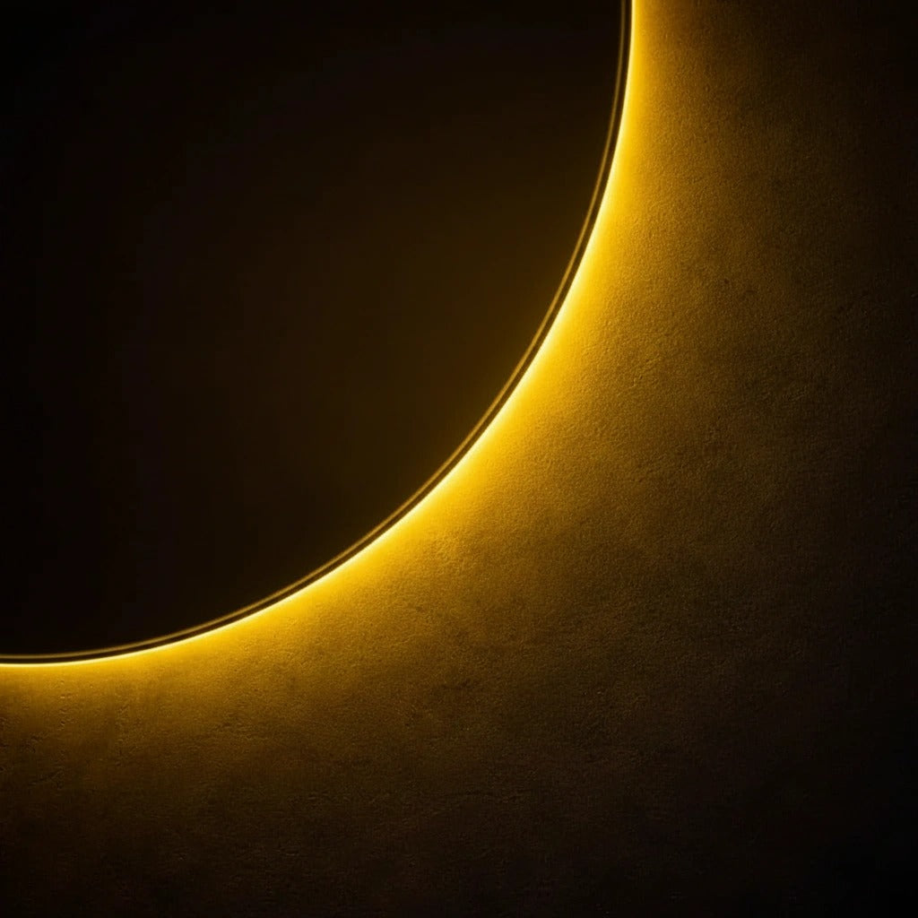 Close-up of the golden-yellow LED halo glowing around the frameless mirror edge