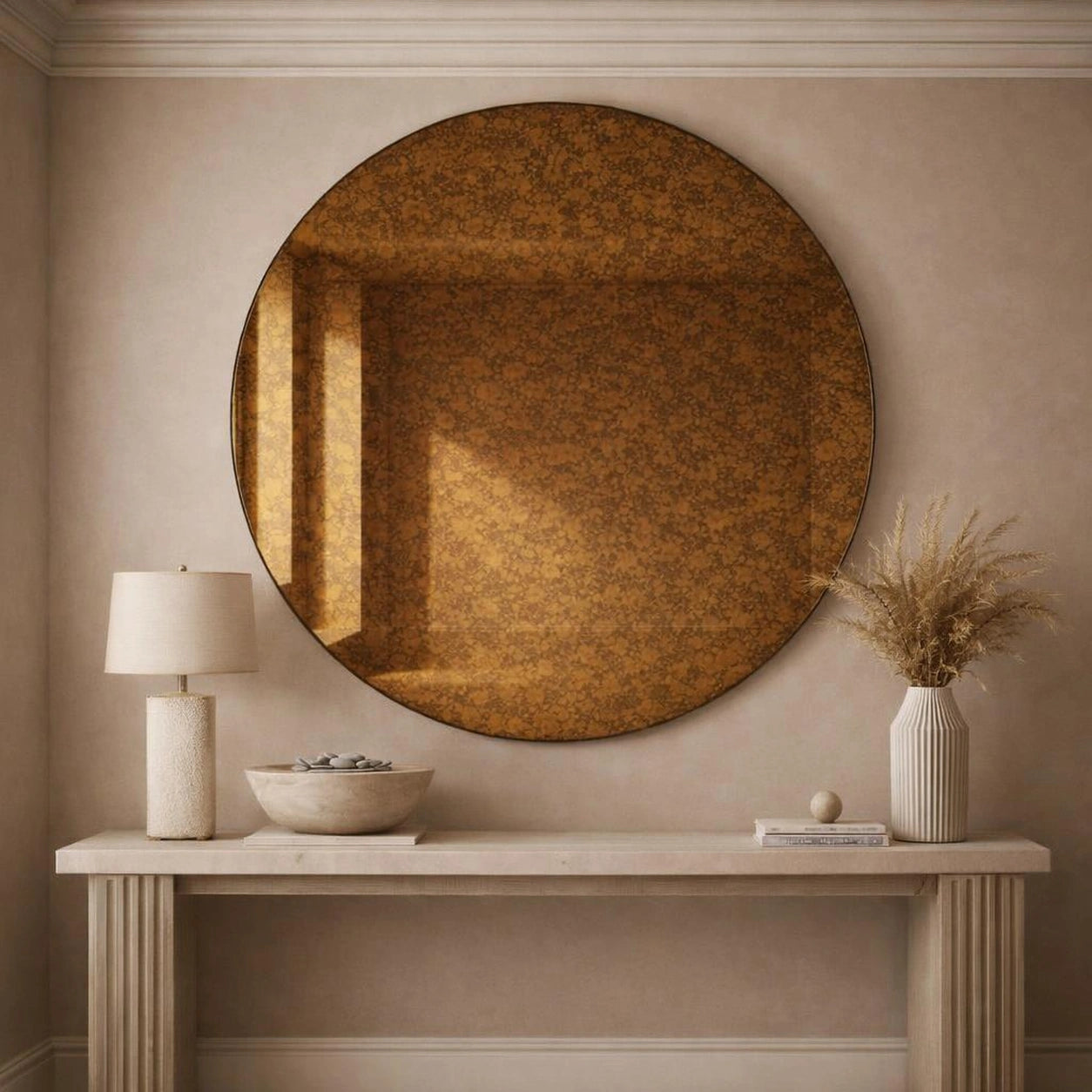 Amber antiqued round mirror hung above a console table in a neutral entryway
