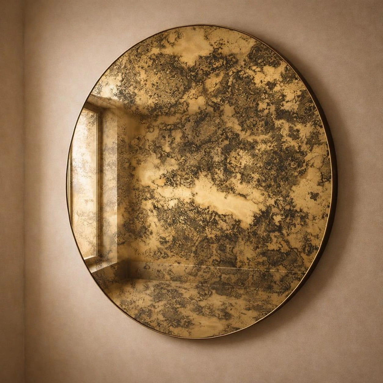 Gold antiqued round wall mirror, angled view showing gilded foxing