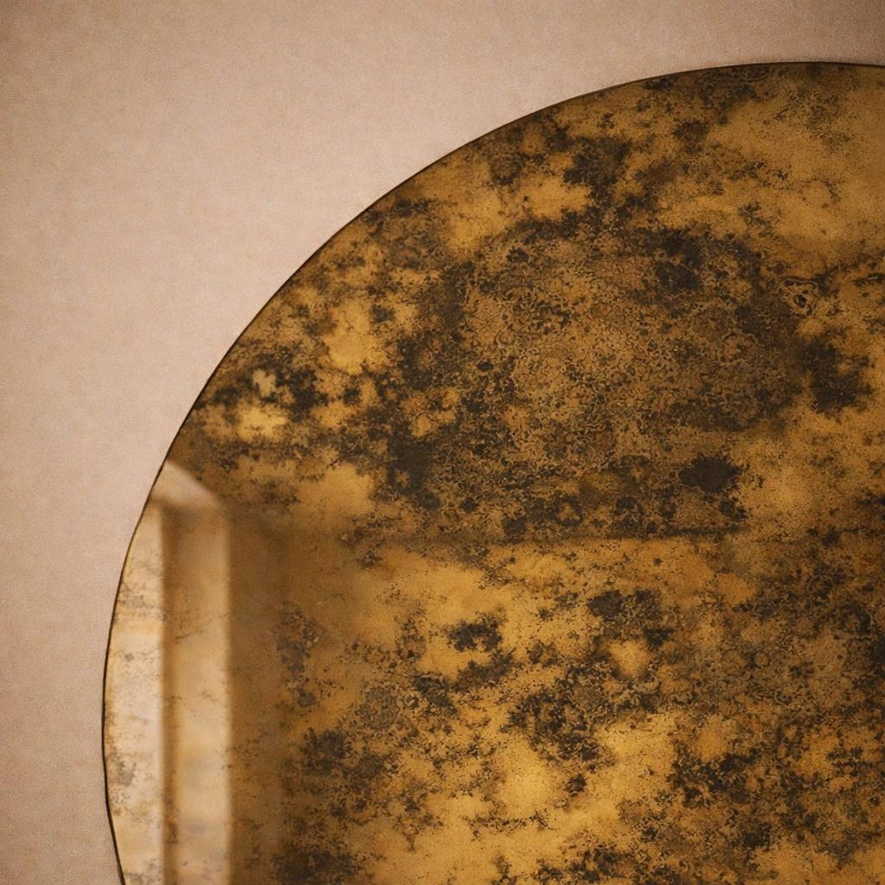 Close-up of gold antiqued mirror surface showing gilded foxing texture