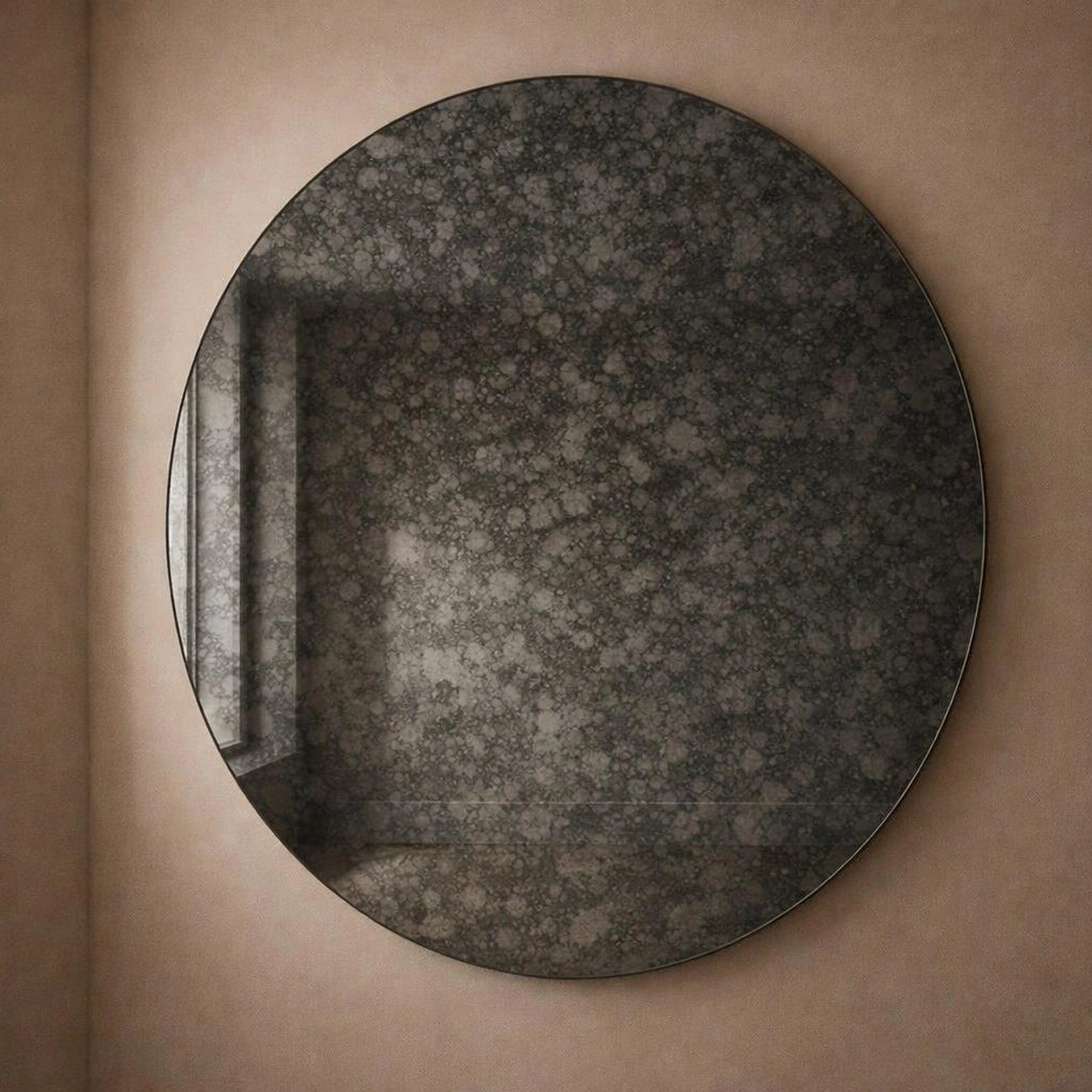 Charcoal antiqued round wall mirror, angled view showing dark foxing