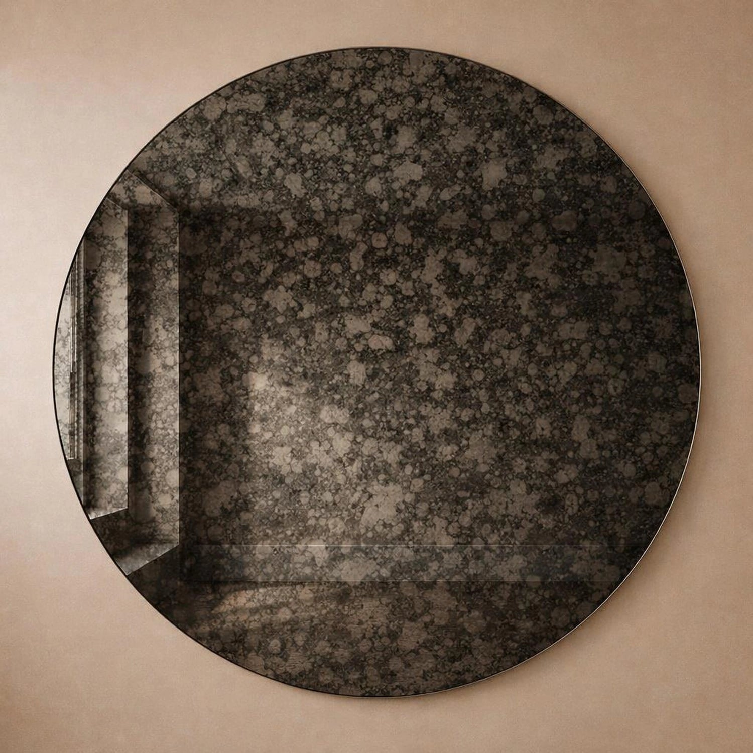 Charcoal antiqued round wall mirror with dark mottled foxing, full frame