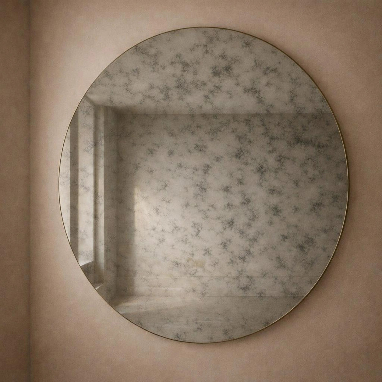 Smoked antiqued round wall mirror, angled view showing light-to-dark foxing