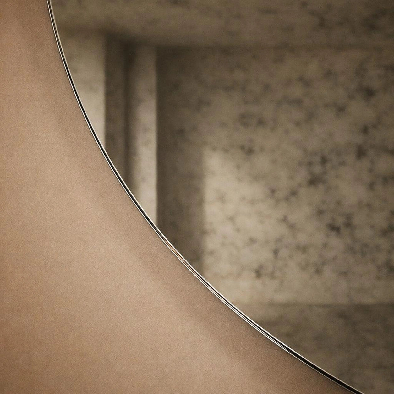 Close-up of a smoked antiqued round mirror frameless edge and foxing