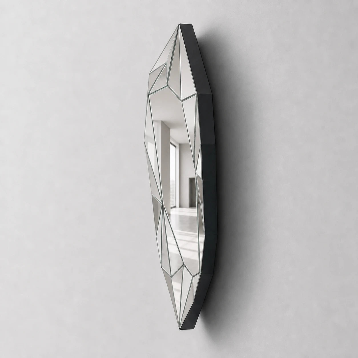 Silver irregular wall mirror showing matte-black side depth