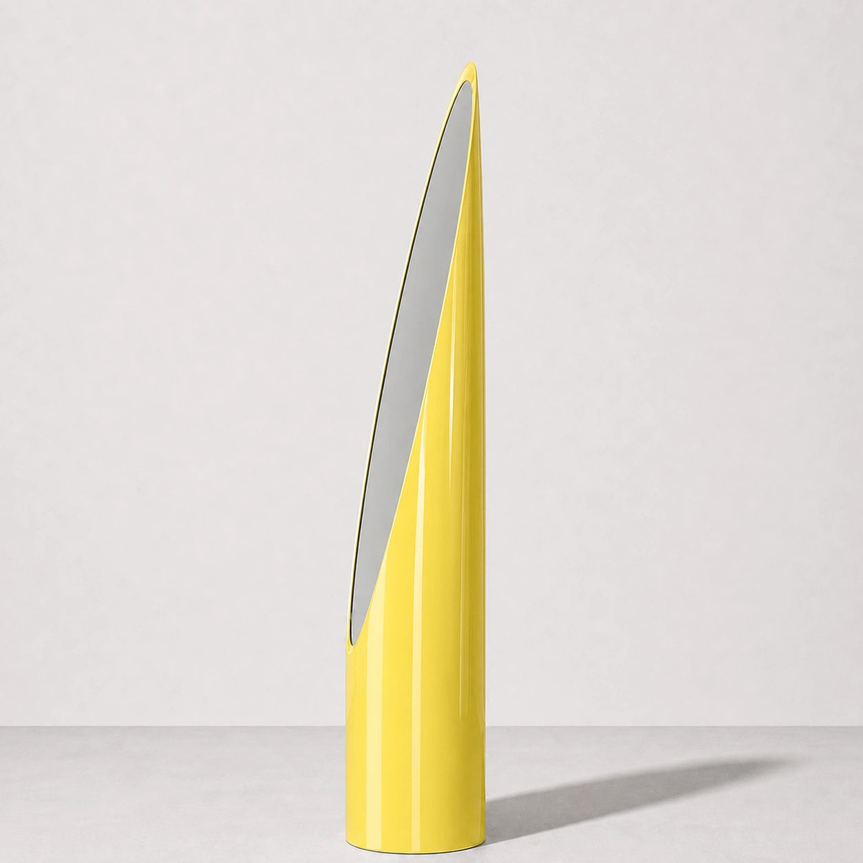 Yellow sculptural Lipstick floor mirror, right three-quarter studio view