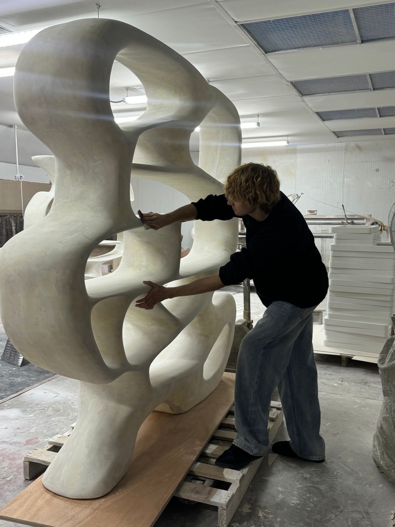 Hand-finishing the Chrome Mirage Bookshelf in the studio